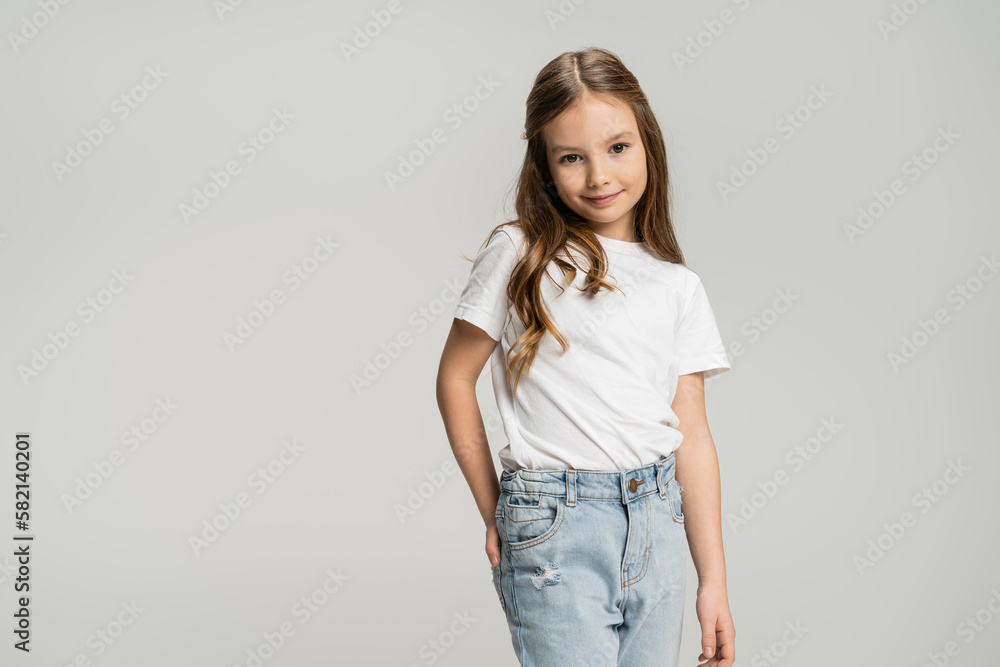 Portrait of positive child posing and looking at camera isolated on grey. Portrait of positive child posing and looking at camera isolated on grey.