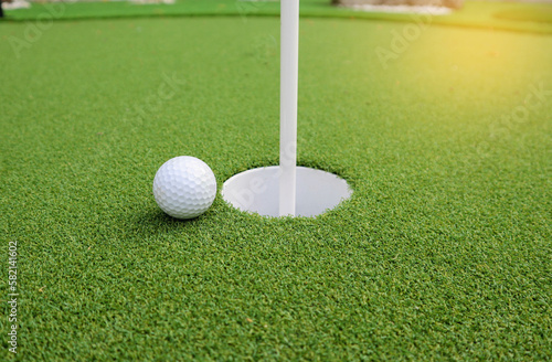 Golf ball next to hole - Sport , hobby and recreation concept
