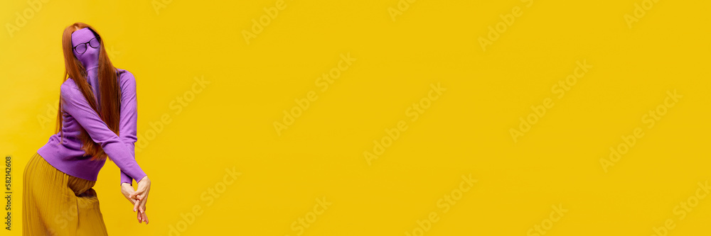 Obraz premium Faceless portrait of slim woman with long straight red hair wearing retro fashion outfit in action over yellow studio background. Impersonal emotions, body language