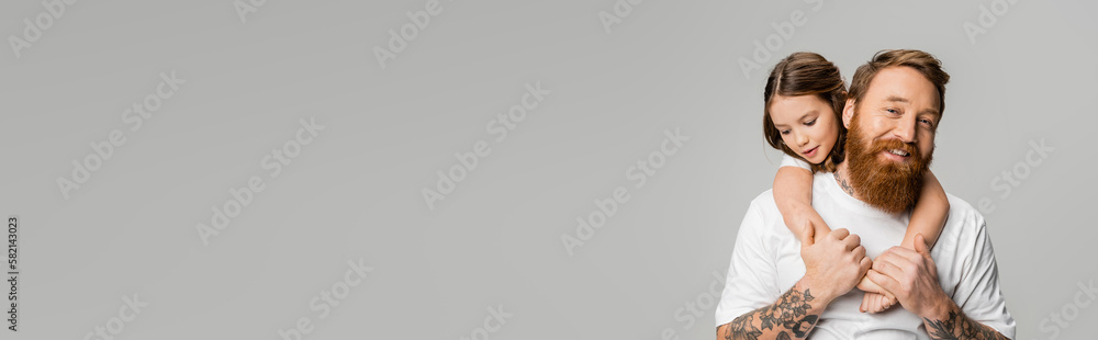 © LIGHTFIELD STUDIOS - Preteen kid hugging smiling tattooed father in white t-shirt isolated on grey, banner. © LIGHTFIELD STUDIOS - Preteen kid hugging smiling tattooed father in white t-shirt isolated on grey, banner.