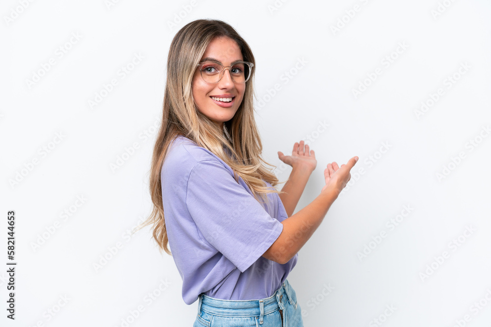 Young Uruguayan woman isolated on white background extending hands to the side for inviting to come Young Uruguayan woman isolated on white background extending hands to the side for inviting to come