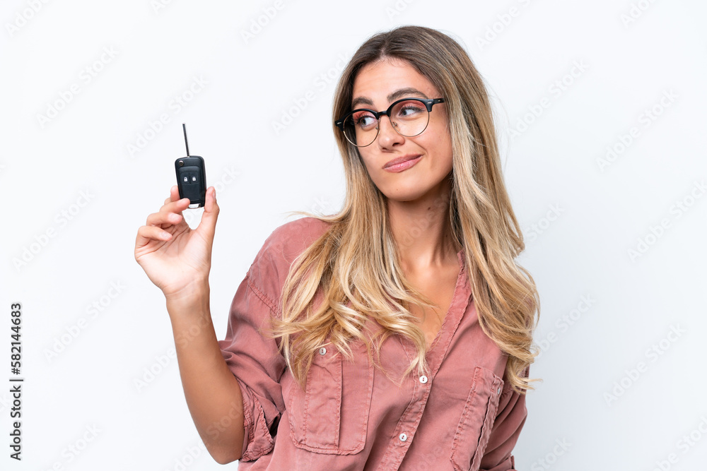 Young pretty Uruguayan woman holding car keys isolated on white background with sad expression