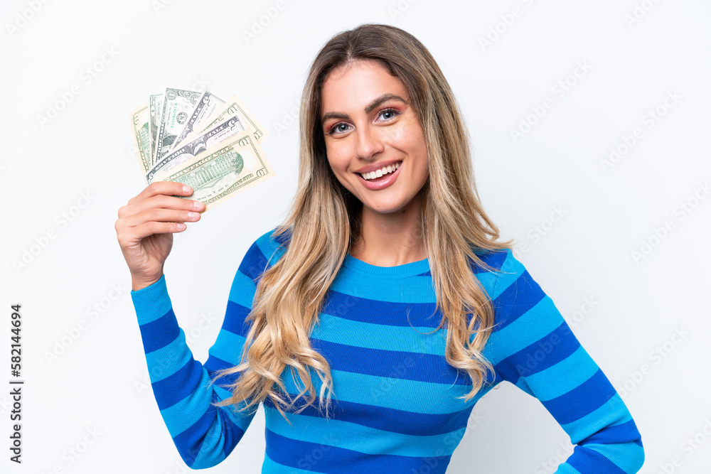 Young Uruguayan woman taking a lot of money isolated on white background posing with arms at hip and smiling Young Uruguayan woman taking a lot of money isolated on white background posing with arms at hip and smiling