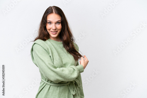 Young caucasian woman isolated on white background pointing back