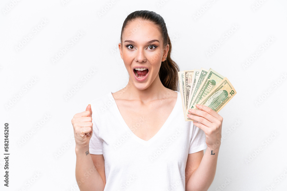 Young caucasian woman taking a lot of money isolated on white background celebrating a victory in winner position Young caucasian woman taking a lot of money isolated on white background celebrating a victory in winner position