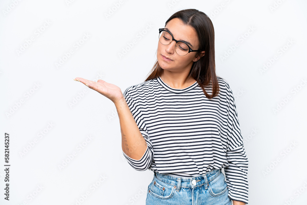 Young caucasian woman isolated on white background holding copyspace with doubts Young caucasian woman isolated on white background holding copyspace with doubts