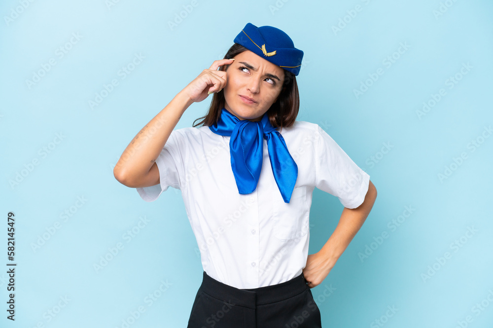 Airplane stewardess caucasian woman isolated on blue background having doubts and with confuse face expression Airplane stewardess caucasian woman isolated on blue background having doubts and with confuse face expression