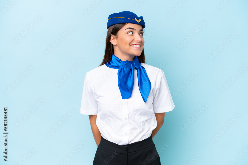 Airplane stewardess caucasian woman isolated on blue background looking side Airplane stewardess caucasian woman isolated on blue background looking side
