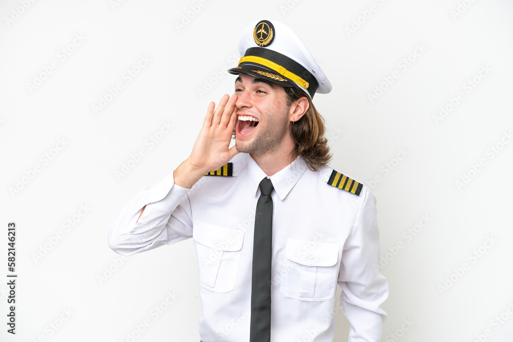 handsome Airplane pilot isolated on white background shouting with mouth wide open to the lateral handsome Airplane pilot isolated on white background shouting with mouth wide open to the lateral