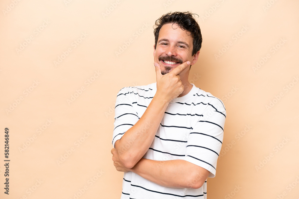 Young caucasian man isolated on beige background happy and smiling Young caucasian man isolated on beige background happy and smiling