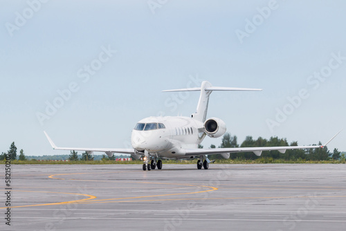 White luxury private jet taxiing on airport taxiway