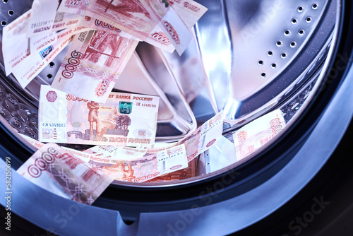 Russian banknotes in the washing machine. Money laundering, financial fraud concept