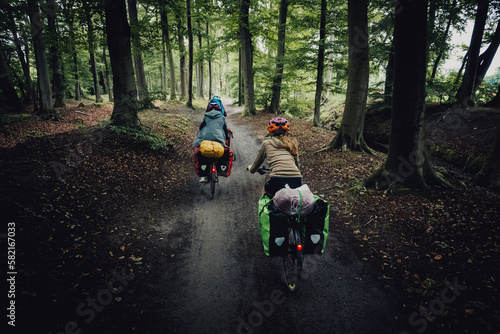 Familie auf einer Fahrradtour fährt durch einen Wald, Niedersachsen, Deutschland