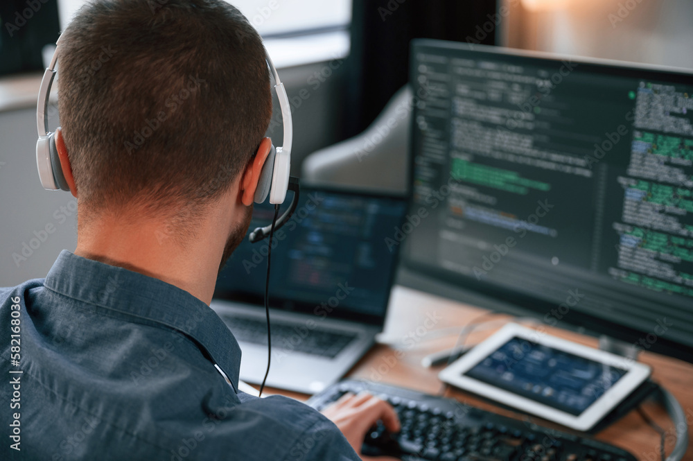 Software developer is writing code. Man in formal clothes is working in the modern office. Using computer Software developer is writing code. Man in formal clothes is working in the modern office. Using computer