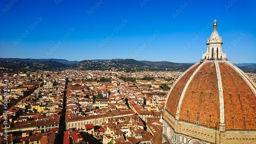 Firenze, Italy - April 7, 2018: aerial view of Florence cityscape and skyline with Brunelleschi's Dome on the right under bright blue sky