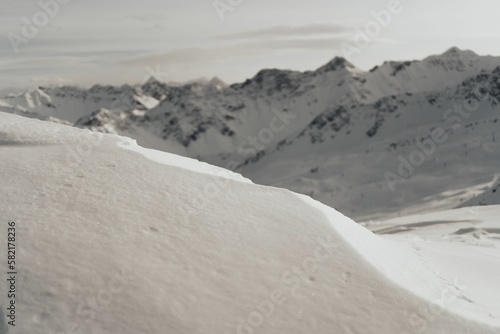 Close-up shot of a snow texture with the view on snowy hill background © Michel Egloff2/Wirestock Creators