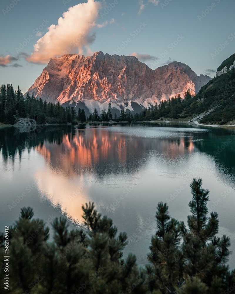 Vertical shot of a lake surrounded by rocky hills during the sunset in Austria