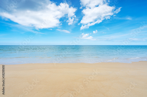 Summer beach sea season greeting background, Tropical sandy beach with blue ocean and blue sky clouds background, image for nature background or summer background