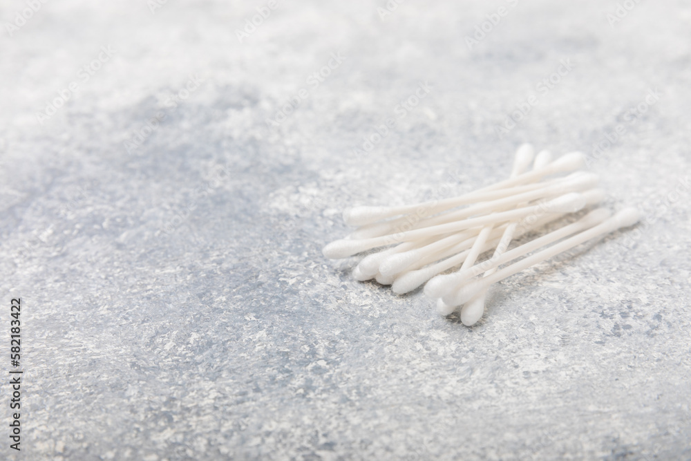 Cotton buds on a concrete table background. Hygienic cotton sticks on a textured background.ear sticks. Place for text. Place to copy.Closeup. Cotton buds on a concrete table background. Hygienic cotton sticks on a textured background.ear sticks. Place for text. Place to copy.Closeup.