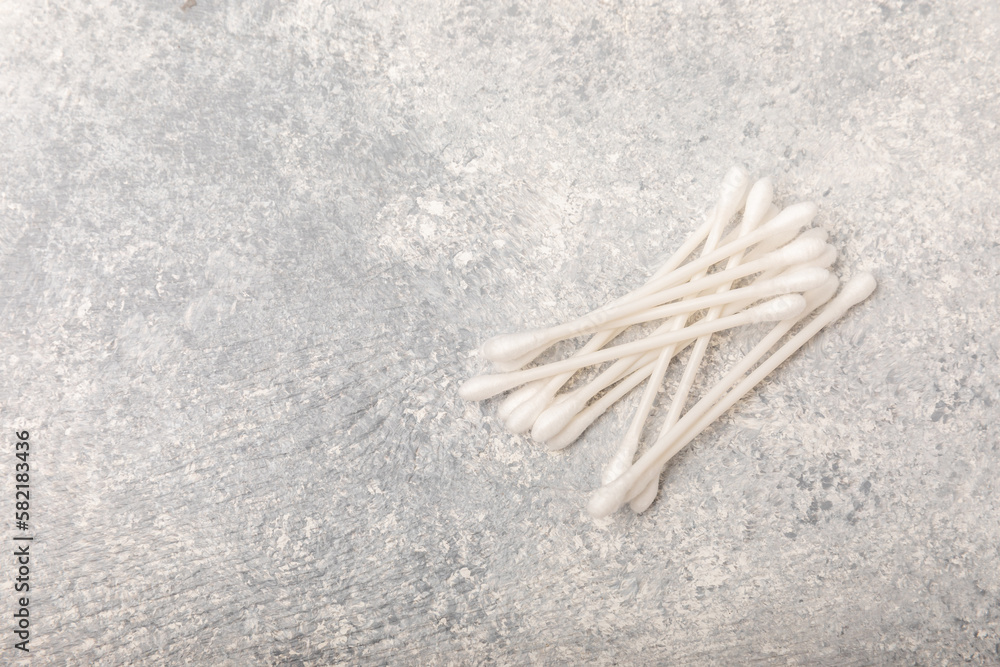 Cotton buds on a concrete table background. Hygienic cotton sticks on a textured background.ear sticks. Place for text. Place to copy.Closeup. Cotton buds on a concrete table background. Hygienic cotton sticks on a textured background.ear sticks. Place for text. Place to copy.Closeup.