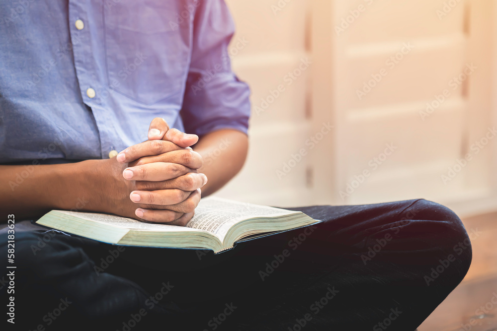 Closeup Man's Praying Hands Over The Bible.	