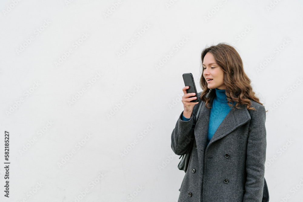 Woman recording voice message on mobile phone on white background Woman recording voice message on mobile phone on white background