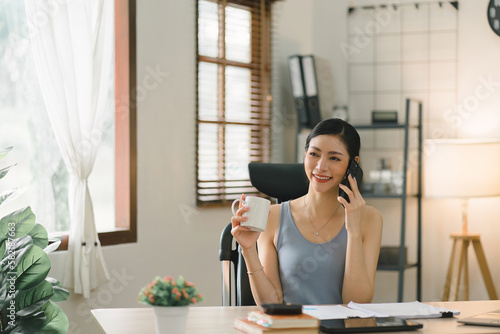 In the image, a cheerful young businesswoman is working from her home office, exemplifying the concept of working remotely.