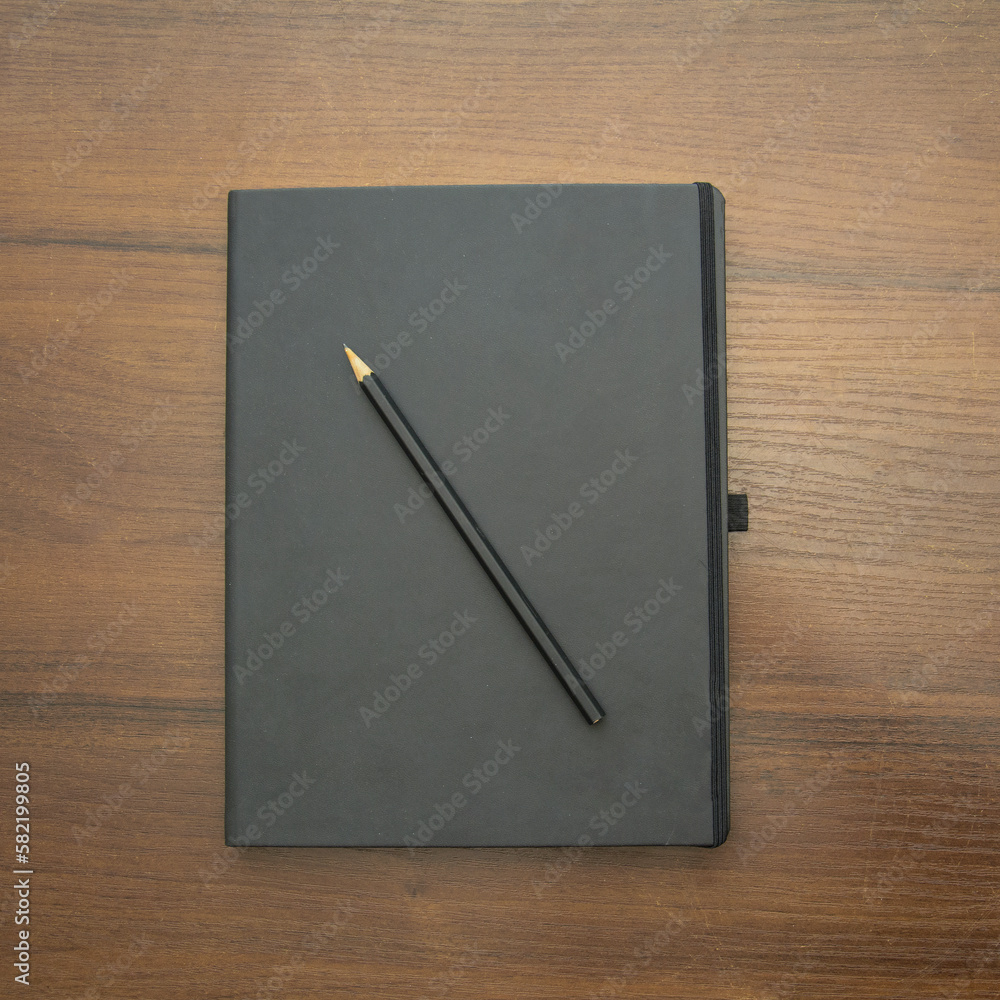 Notebook and pencil on a beautiful background in a photo studio Notebook and pencil on a beautiful background in a photo studio