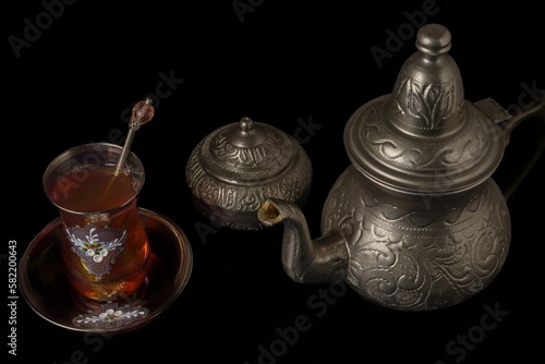 decorated tea glass with teapot and metal sugar bowl