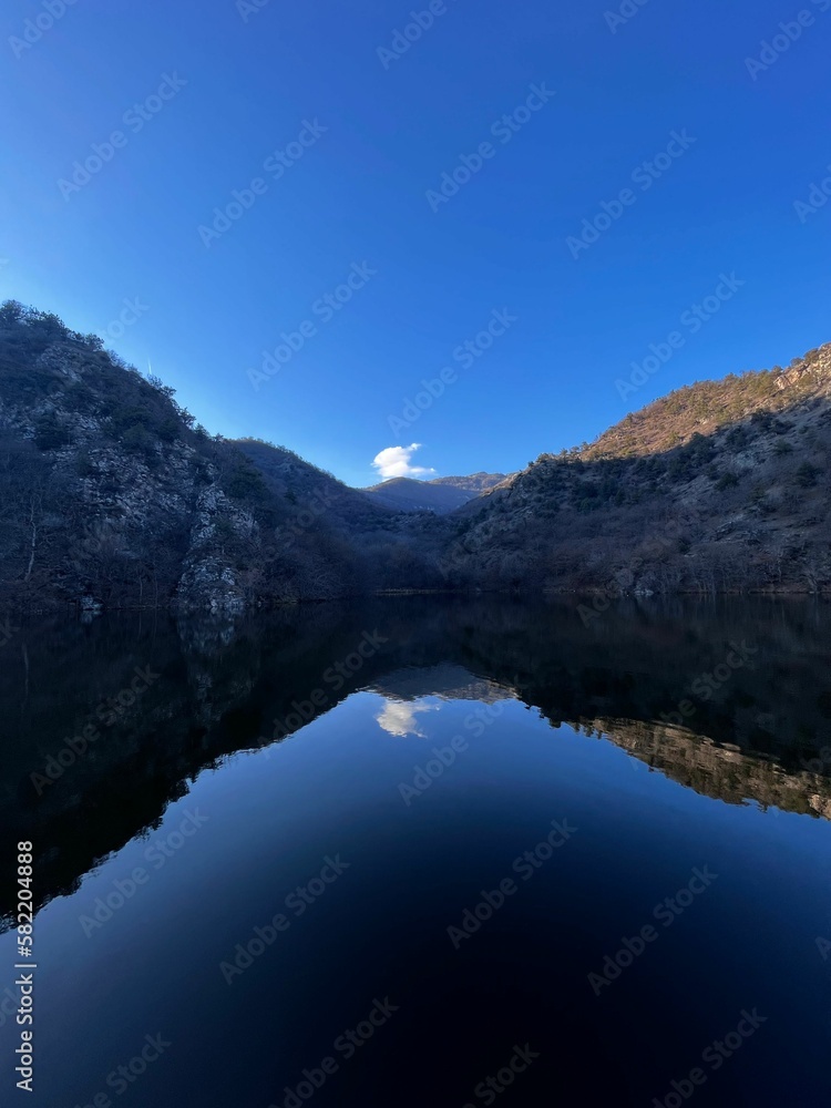 Vertical shot of a calm lake surrounded by mountains
