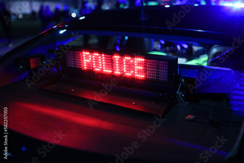 Napis police - świeci na szybie radiowozu policji. 