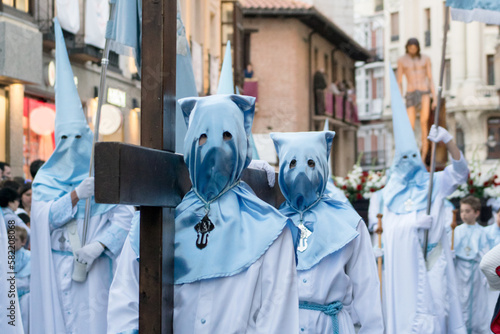 Dos cofrades portan una cruz de madera de gran tamaño durante una de las procesiones de Semana Santa en Valladolid, España. Hermandad de Nuestro Padre Atado a la Columna. photo