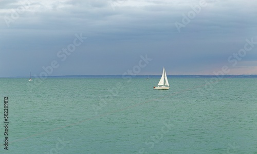Boat in the sea with a cloudy sky in the background © Laurent Renault/Wirestock Creators