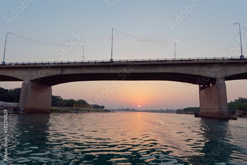 Stone bridge over a river at sunset © Ivica Gulija/Wirestock Creators