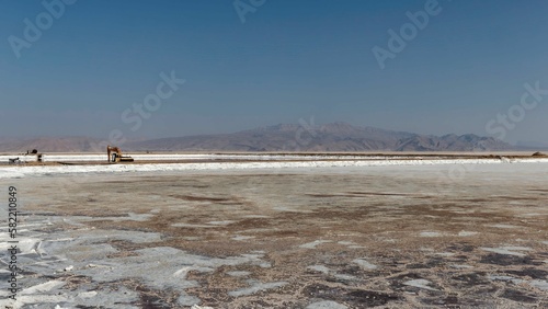 Landscape shot of the process of loading salt onto a truck at Maharlu lake in Shiraz, Iran photo