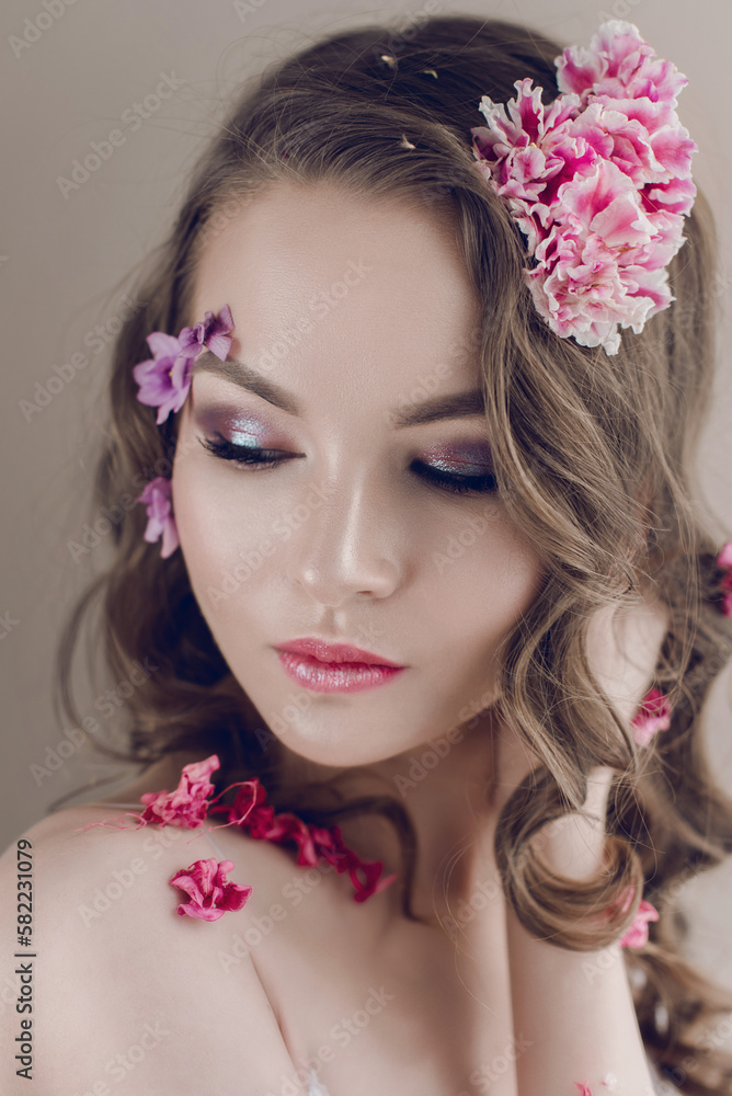 Cosmetics and manicure. Close-up portrait of attractive woman with dry flowers on her face and hair, pastel color, perfect make-up and skin on blue background. Fresh, trendy, spring retouched portrait Cosmetics and manicure. Close-up portrait of attractive woman with dry flowers on her face and hair, pastel color, perfect make-up and skin on blue background. Fresh, trendy, spring retouched portrait