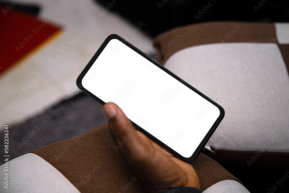 Black Hand holding mobile phone with transparent blank png screen in living room Black Hand holding mobile phone with transparent blank png screen in living room