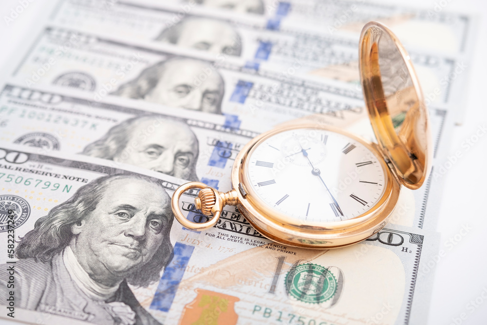 Macro shot of pocket watch face with 100 dollar bill Ben Franklin money and time concept - old pocket watch on pile of american bill dollars Macro shot of pocket watch face with 100 dollar bill Ben Franklin money and time concept - old pocket watch on pile of american bill dollars