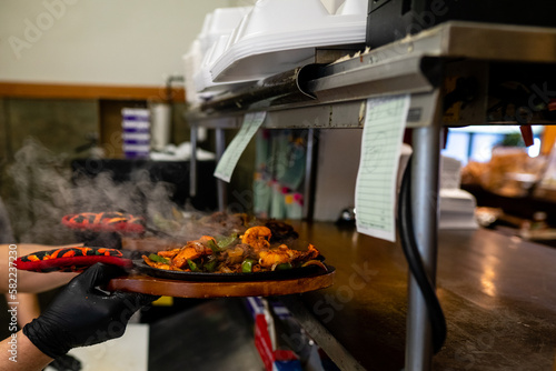 Chef placing hot fajitas in the in the order window at a traditional mexican restaraunt