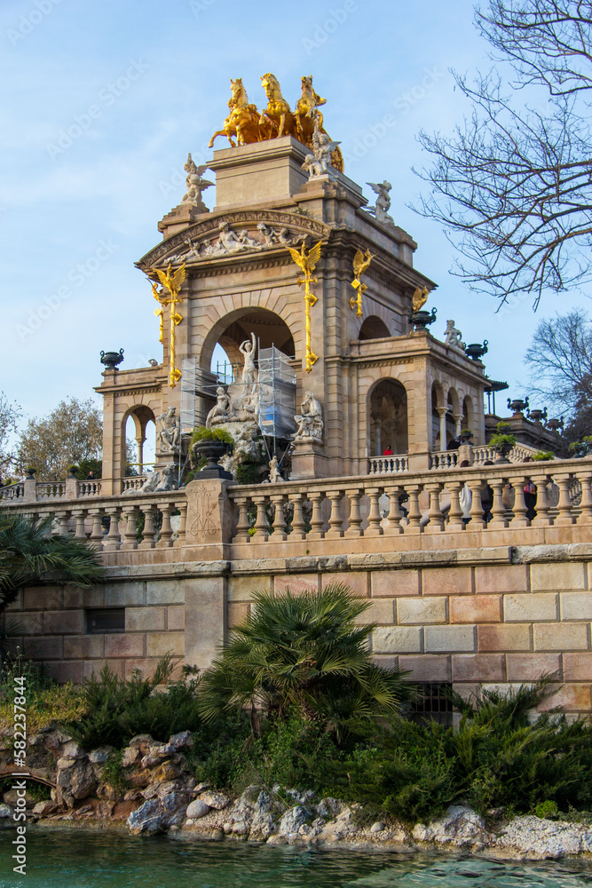 Ornate architecture with golden statues on top in a park in Barcelona, Spain.