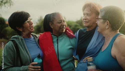 Happy multiracial senior women having fun after workout exercises in the park