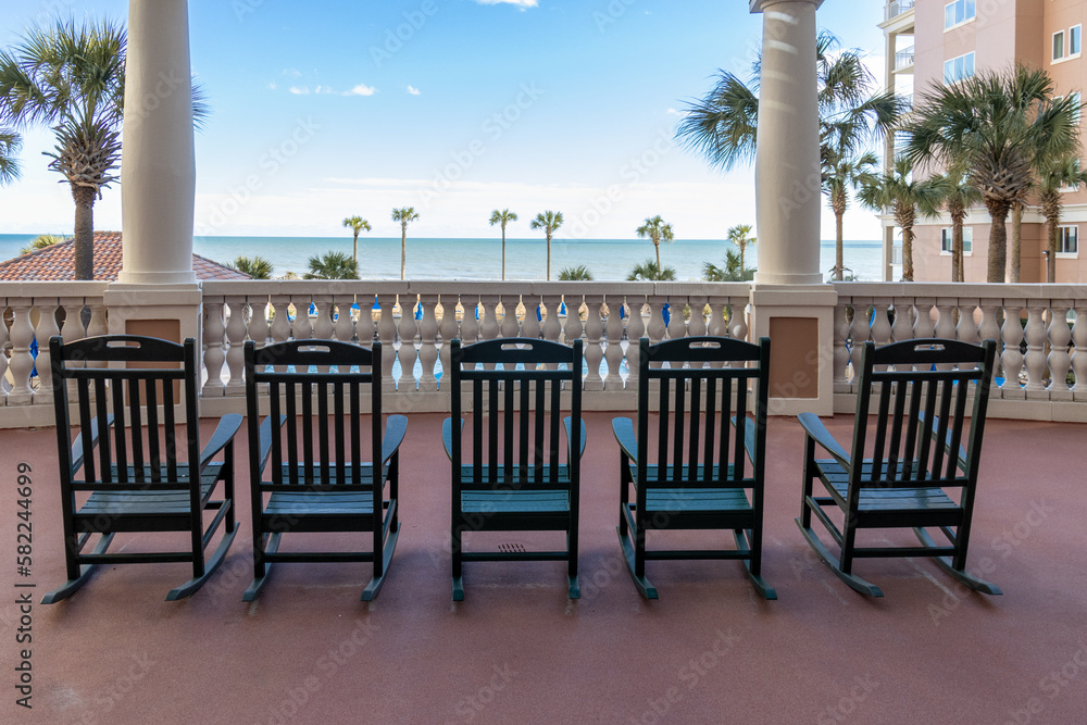 rocking chairs on the terrace overlooking ocean and blue sky rocking chairs on the terrace overlooking ocean and blue sky