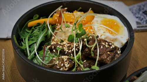 Bibimbap and rice with meat. Korean dish. Spicy food. Egg yolk on top of rice. Delicious and hearty Asian food