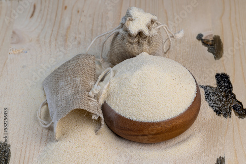 Semolina poured into a round wooden bowl ready for cooking