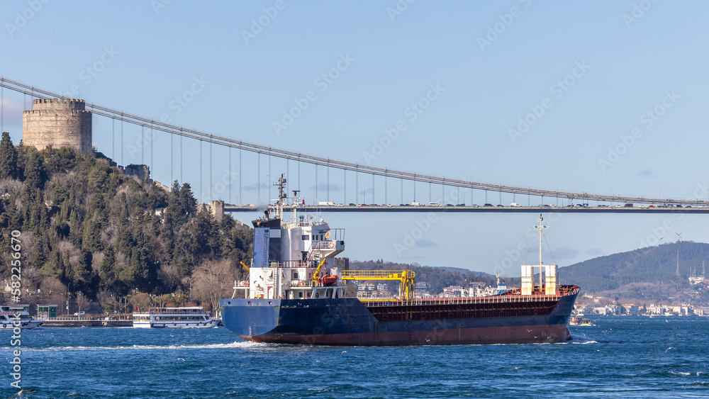 Tanker ship pass through the Bosporus with Bosphorus Bridge in Istanbul, Turkey or Turkiye, Bosphorus strait connecting Europe to Asia, Tanker ship in Istanbul, Turkey.
