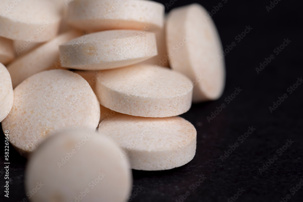 White and yellow medical medicines on a black background White and yellow medical medicines on a black background