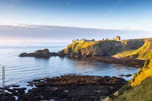 Obraz na plátně Dunnottar Castle bathed in gorgeous morning sun, taken from the cliffs above Castle Haven near Stonehaven in Aberdeenshire