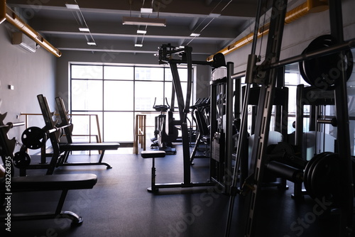 
Sports equipment in the gym. Stylish bright sports space. Expanders and simulators with heavy dumbbells.
Bench press, sport for a strong body and weight loss