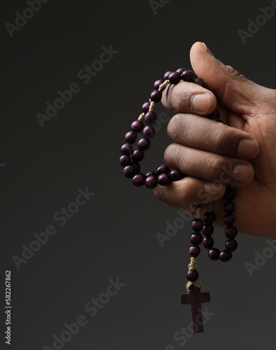 praying to god with cross and hands together with black background with people stock photo 