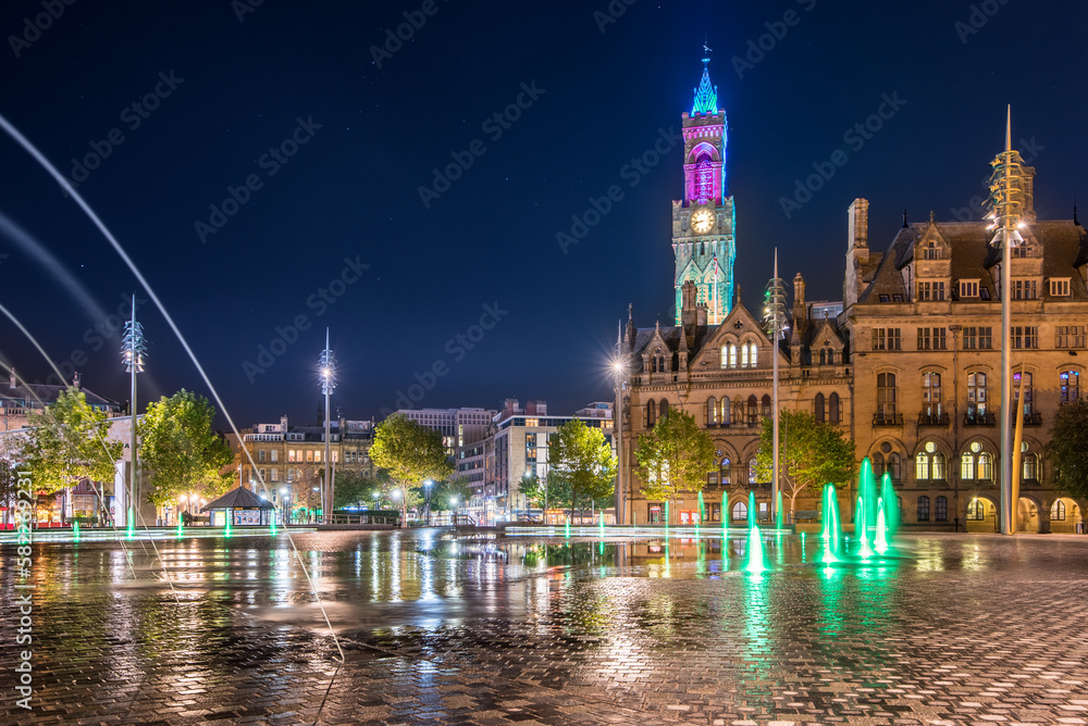 Night view of illuminated clock tower and fountain at  Centenary Square Bradford UK